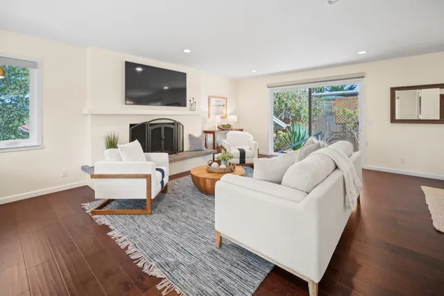 a living room with furniture a fireplace and a flat screen tv