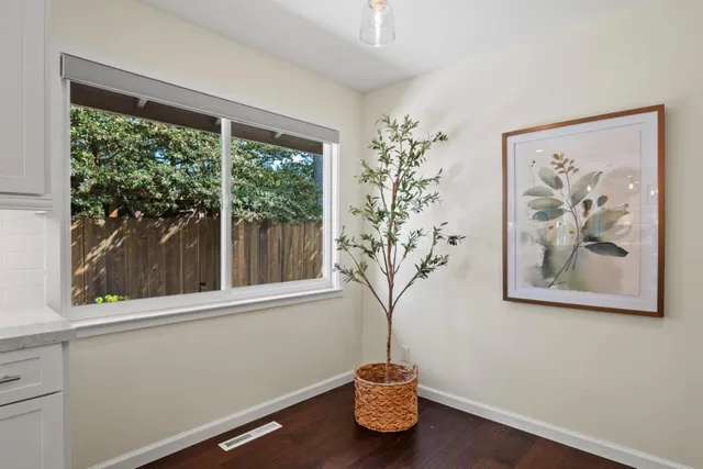 a view of a room that has a window and wooden floor