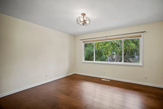 a view of a room with wooden floor and a window