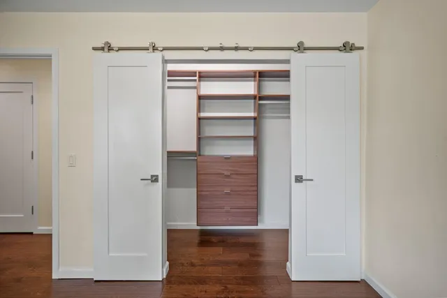 a view of walk in closet with empty racks