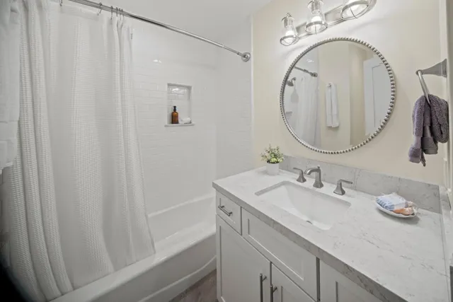 a bathroom with a sink vanity granite and a mirror