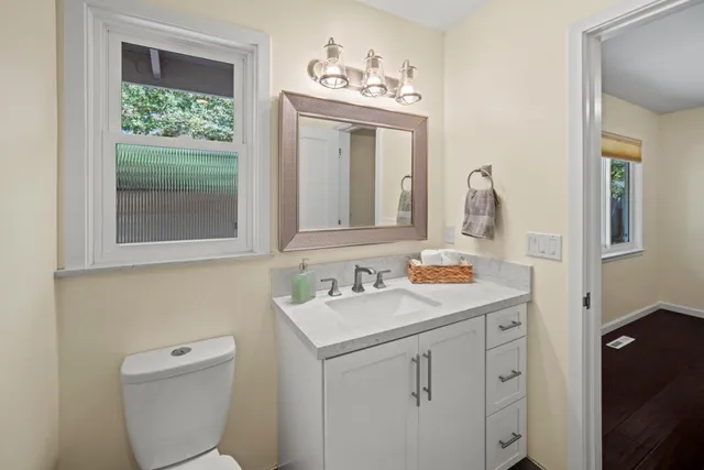 a bathroom with a toilet sink and mirror
