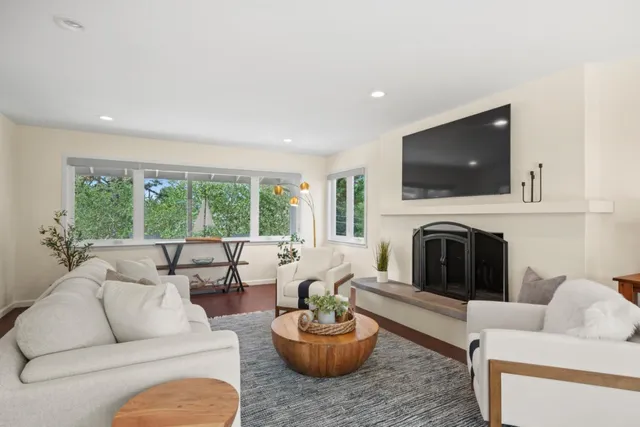 a living room with furniture a flat screen tv and a fireplace