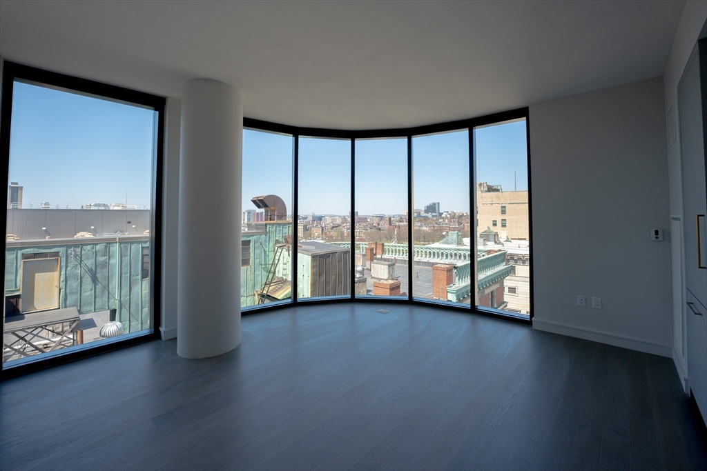 55 Lagrange Street, Unit 1708 Boston, MA 02111 - Photo 14 of 18 a view of an empty room with wooden floor and a window