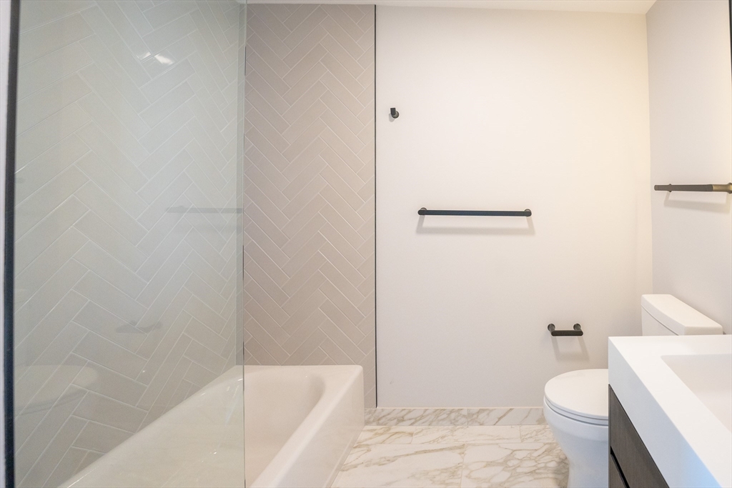 55 Lagrange Street, Unit 1708 Boston, MA 02111 - Photo 16 of 18 a bathroom with a granite countertop toilet and a bathtub