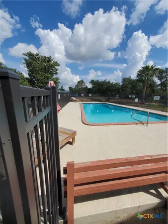 a swimming pool with lots of tress in front of it