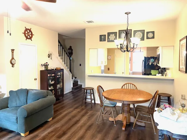 a living room with furniture a chandelier and a wooden floor
