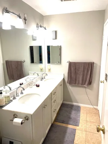 a spacious bathroom with a tub sink and mirror