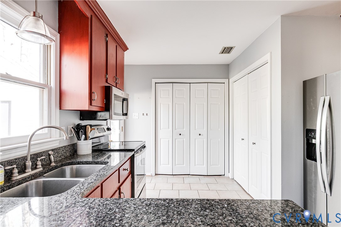 14710 Mill Spring Drive Midlothian, VA 23112 - Photo 8 of 24 a kitchen with stainless steel appliances granite countertop a sink a stove and a refrigerator