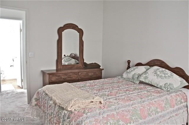 2119 Blue Jay Road Overgaard, AZ 85933 - Photo 11 of 28 a bedroom with a bed and a potted plant on the dresser