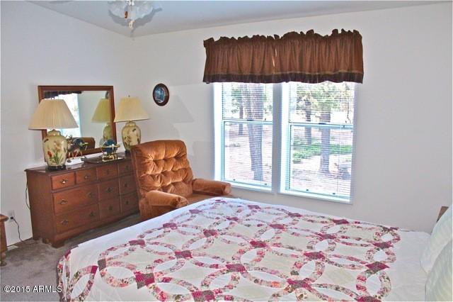 2119 Blue Jay Road Overgaard, AZ 85933 - Photo 9 of 28 a bedroom with a bed and a window