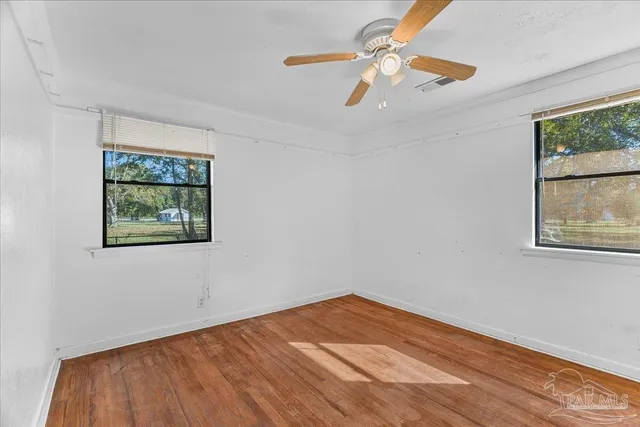 a view of empty room with wooden floor