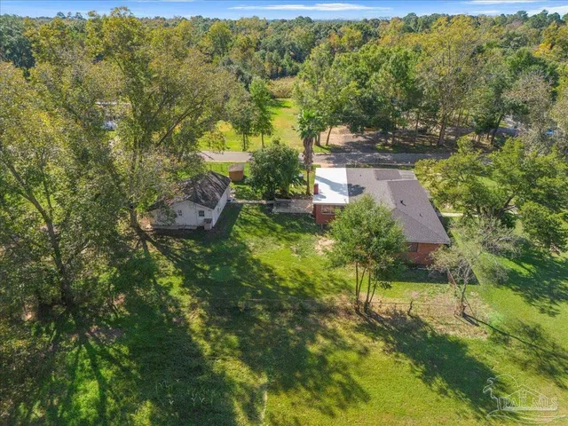 a front view of a house with a garden and trees