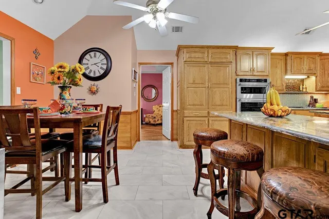a view of a dining room and kitchen with furniture and a clock
