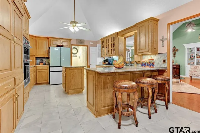 a dining table chairs and a refrigerator in a kitchen
