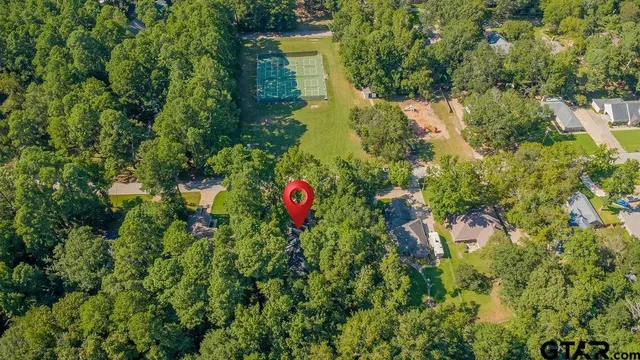 an aerial view of residential house with outdoor space and trees all around