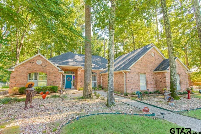a view of a house with a yard and large tree