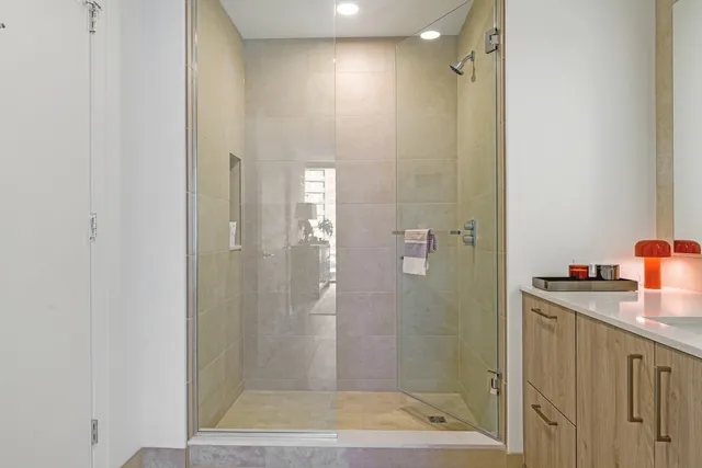 a bathroom with a granite countertop sink a shower and a mirror