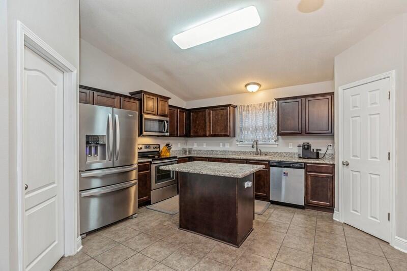 4640 Hermosa Road Crestview, FL 32539 - Photo 10 of 37 a large kitchen with stainless steel appliances granite countertop a stove top oven a refrigerator and a sink