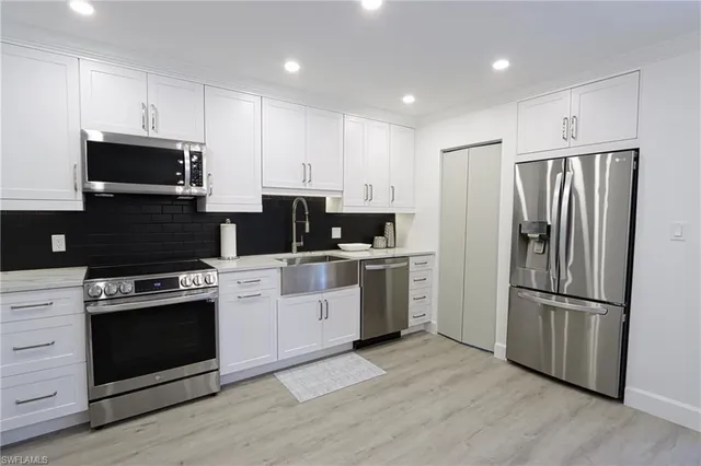 a kitchen with granite countertop white cabinets and a stove