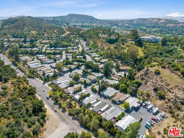 an aerial view of residential houses with outdoor space and trees