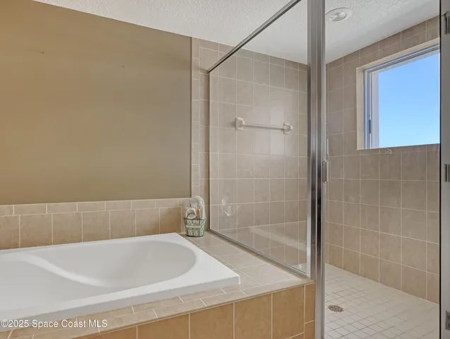 a view of white house with a plants and palm trees