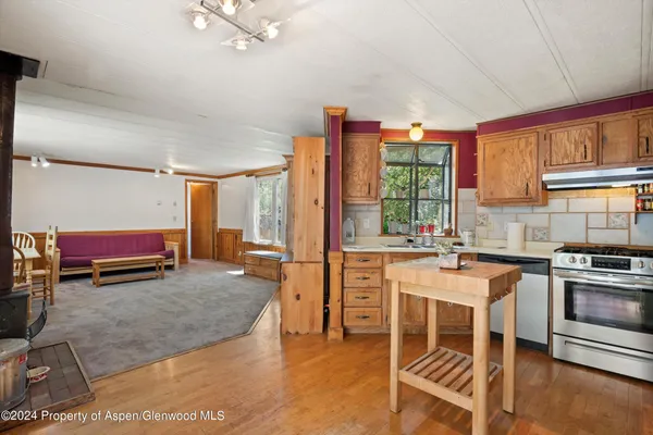 a room with stainless steel appliances kitchen island granite countertop a stove and a refrigerator