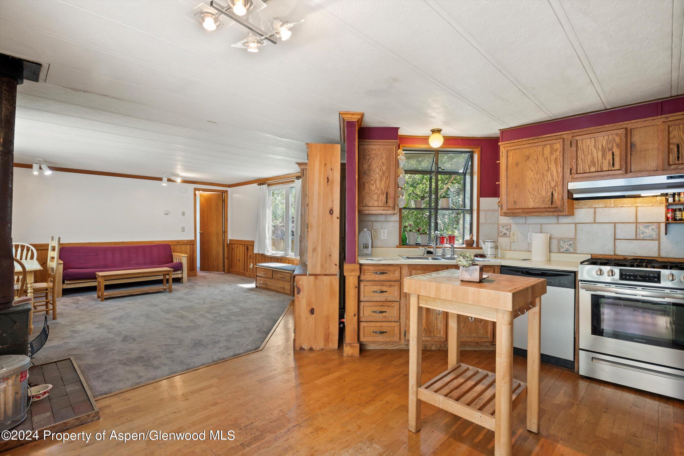 a room with stainless steel appliances kitchen island granite countertop a stove and a refrigerator