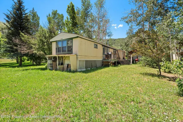a white house that has a tree in front of it