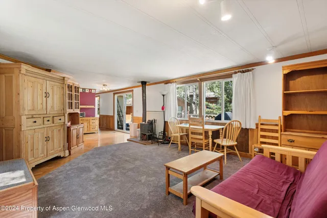 a living room with furniture a flat screen tv and large window
