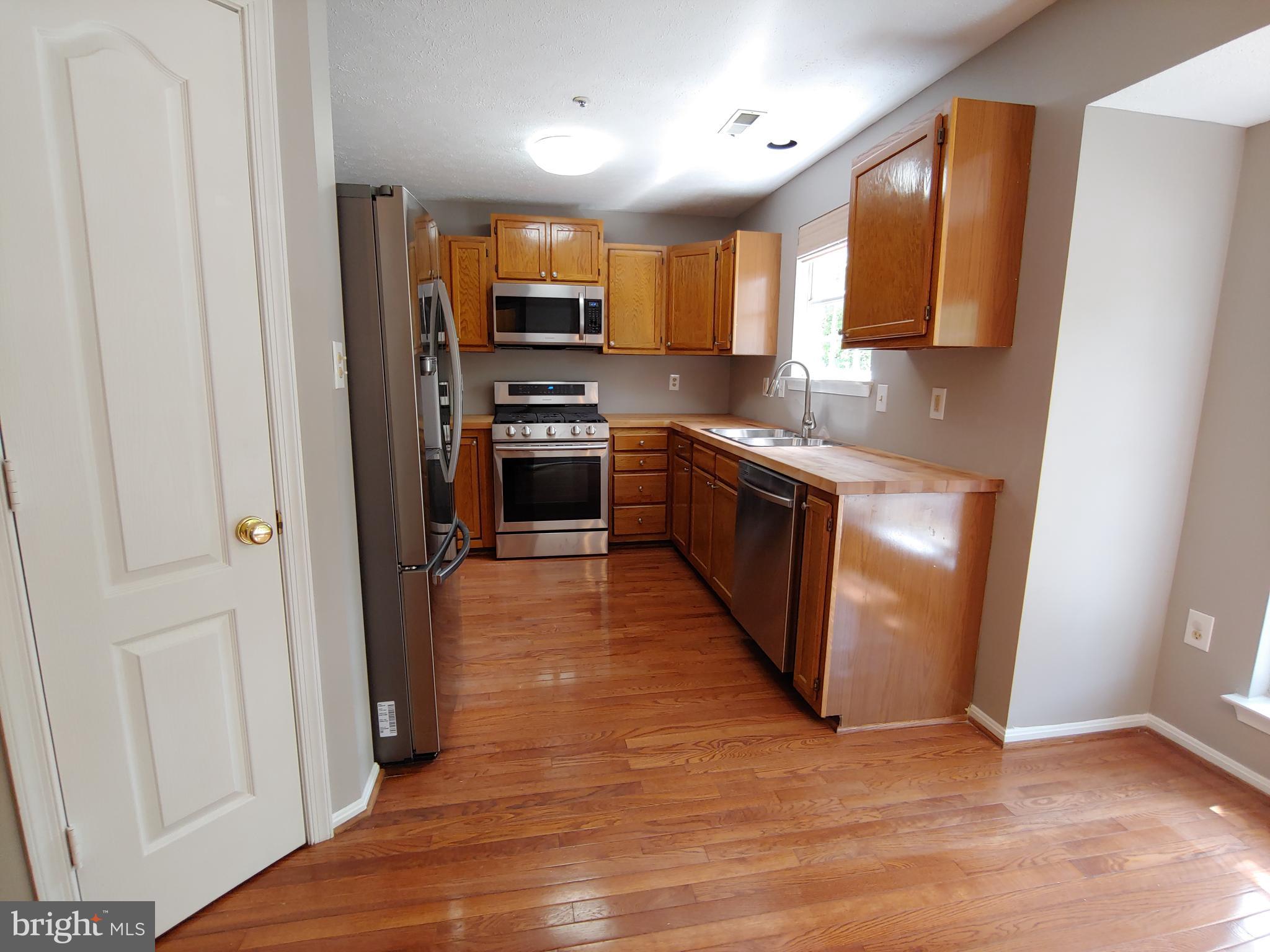 6010 Grenfell Loop Bowie, MD 20720 - Photo 12 of 32 a kitchen with stainless steel appliances granite countertop a refrigerator a sink a stove a microwave and island