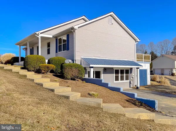 a view of a white house with a yard outdoor space and sitting space