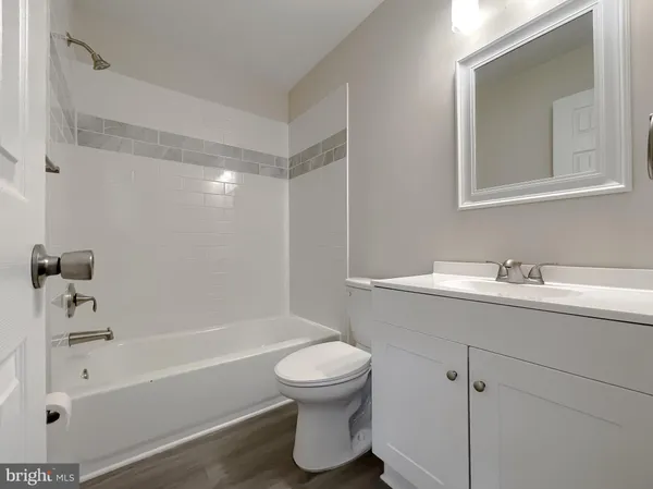 a bathroom with a bathtub shower sink vanity and toilet