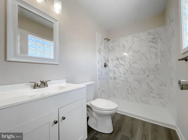 a bathroom with a toilet sink vanity and mirror