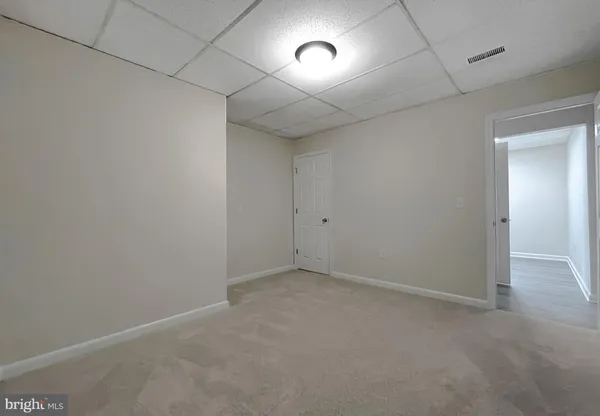 an empty room with an entryway and fan