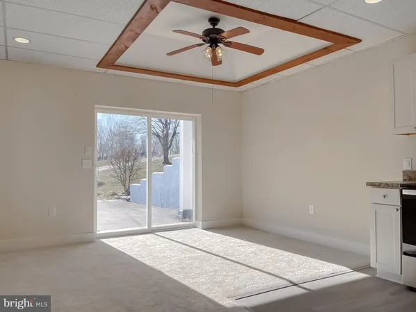 a view of a room with a ceiling fan and window