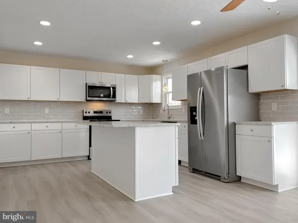 a kitchen with a refrigerator a stove top oven a sink and cabinets