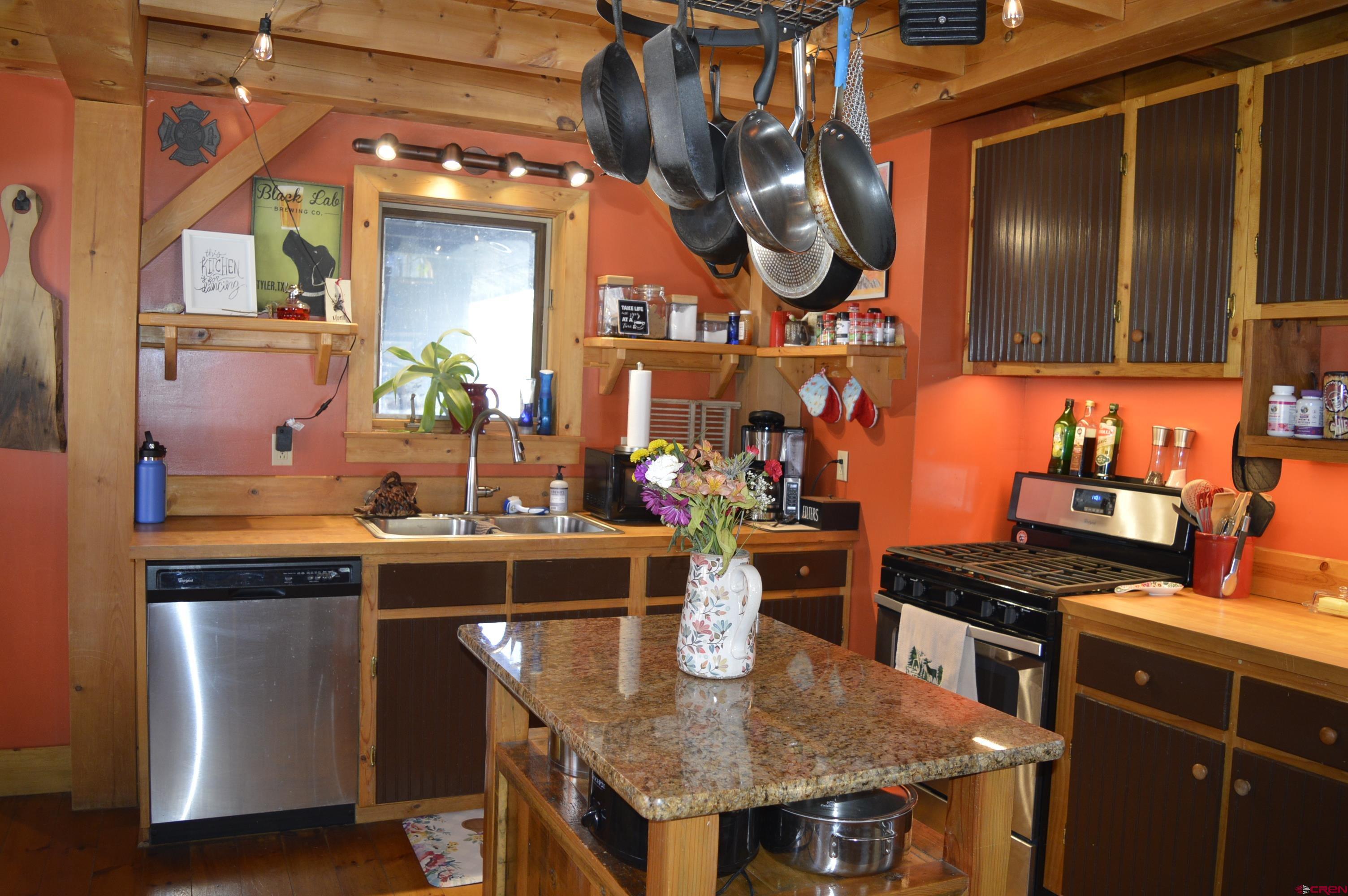 1505 Cement Street Silverton, CO 81433 - Photo 7 of 21 a kitchen with stainless steel appliances granite countertop a sink a stove and a wooden cabinets