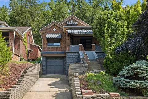 a front view of a house with a garden