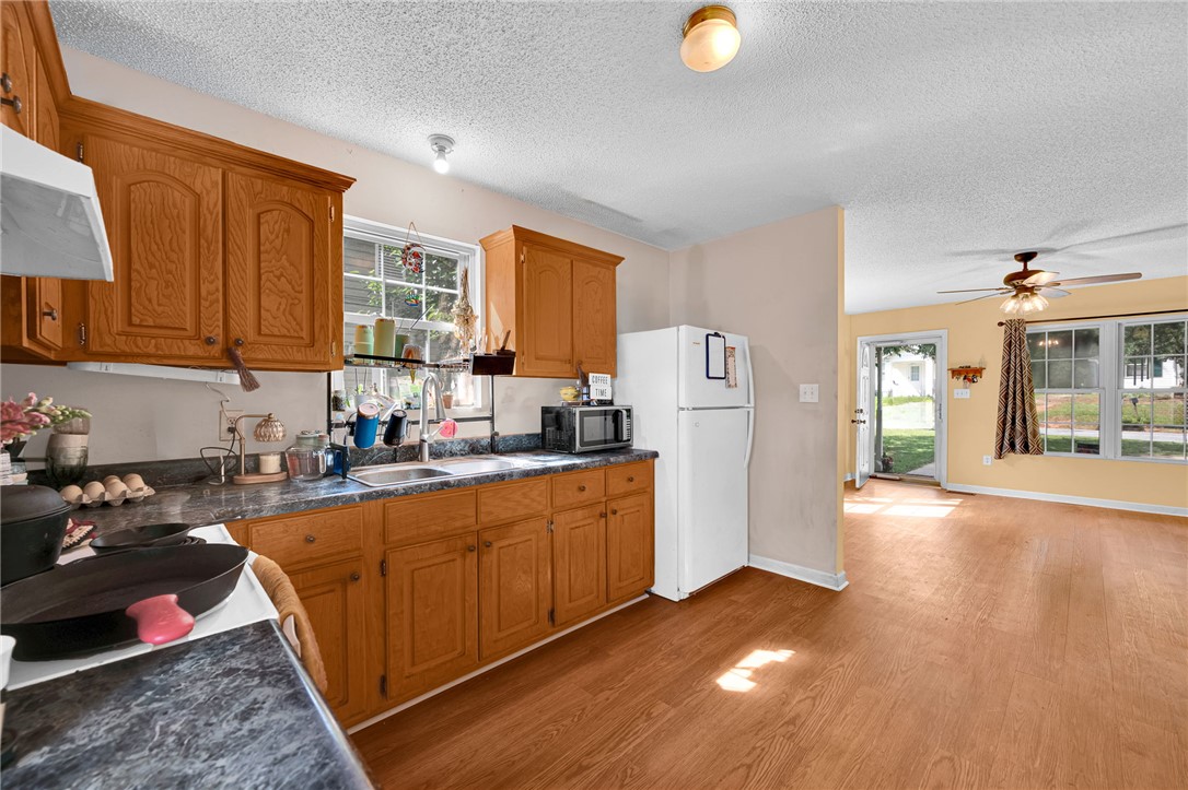 1020 Elizabeth Street Anderson, SC 29624 - Photo 11 of 22 Functional kitchen with ample cabinet space opens to an airy living area, featuring rich wood-look flooring.