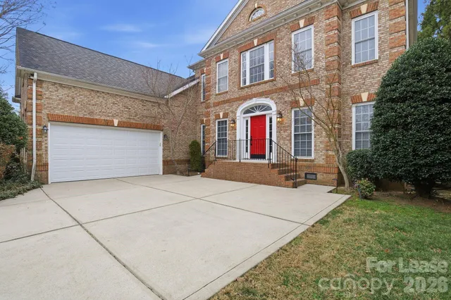 front view of a brick house with a yard