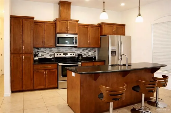 a kitchen with kitchen island a counter top space appliances and cabinets