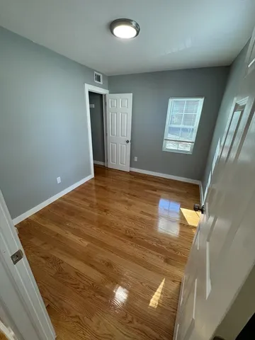 a view of empty room with wooden floor