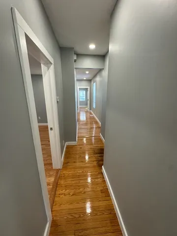 a view of a hallway with wooden floor and staircase