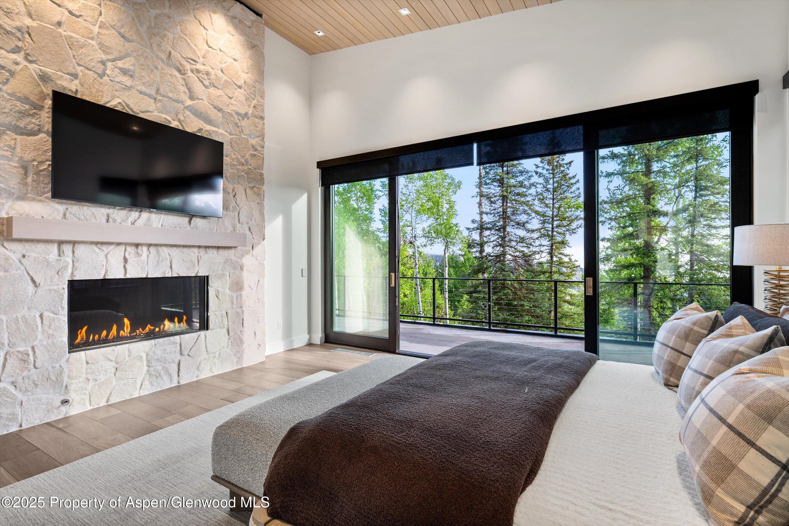 1234 Wood Road Snowmass Village, CO 81615 - Photo 38 of 66 a bed room with a bed and a fireplace