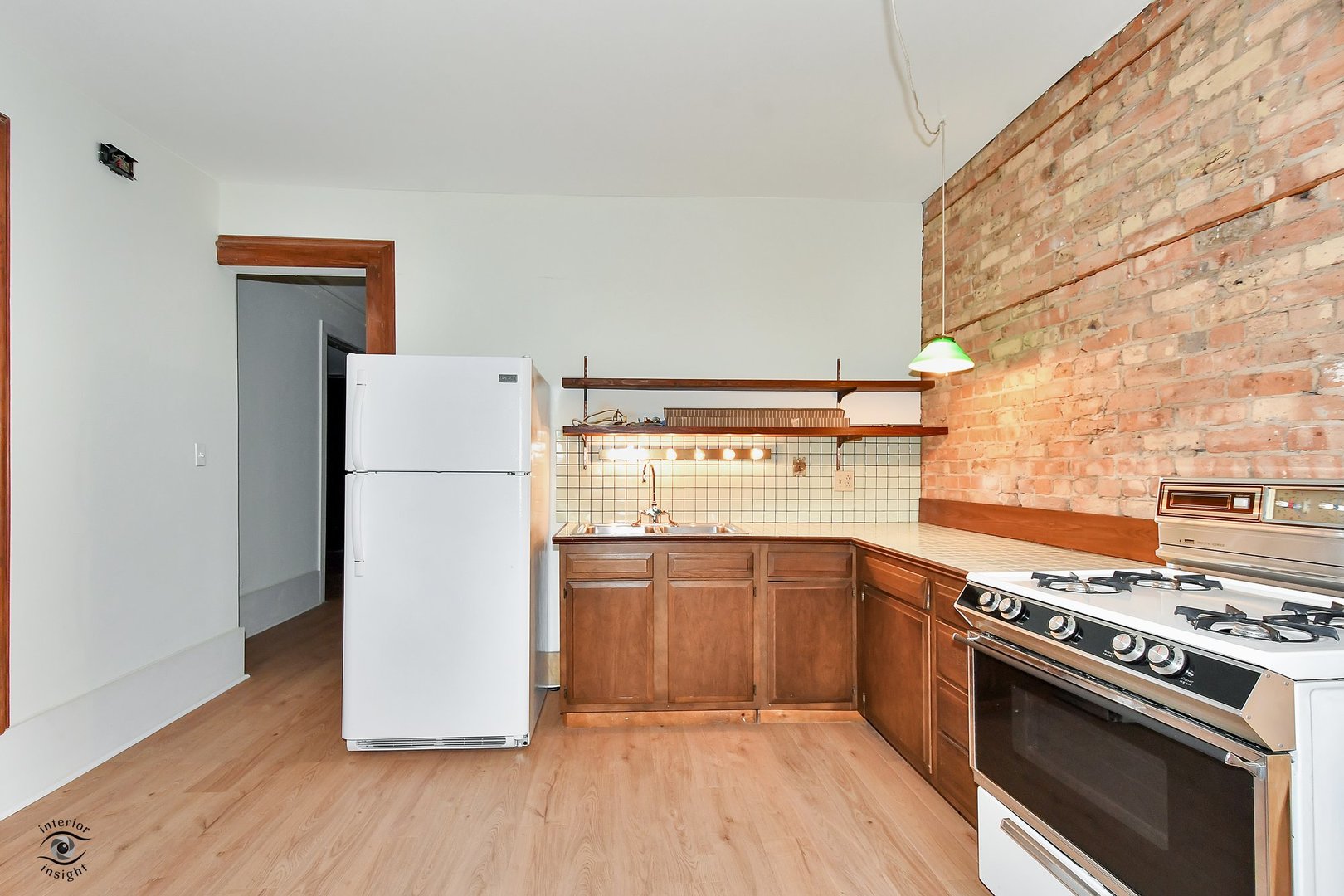1515 West Jackson Boulevard Chicago, IL 60607 - Photo 11 of 21 a kitchen with a stove a refrigerator and a wooden floor