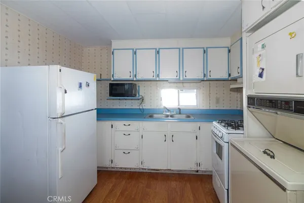 a kitchen with granite countertop a sink a stove and refrigerator