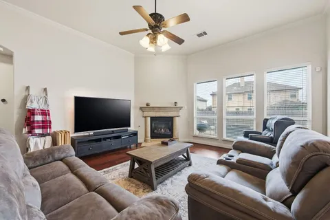 a living room with furniture flat screen tv and a large window