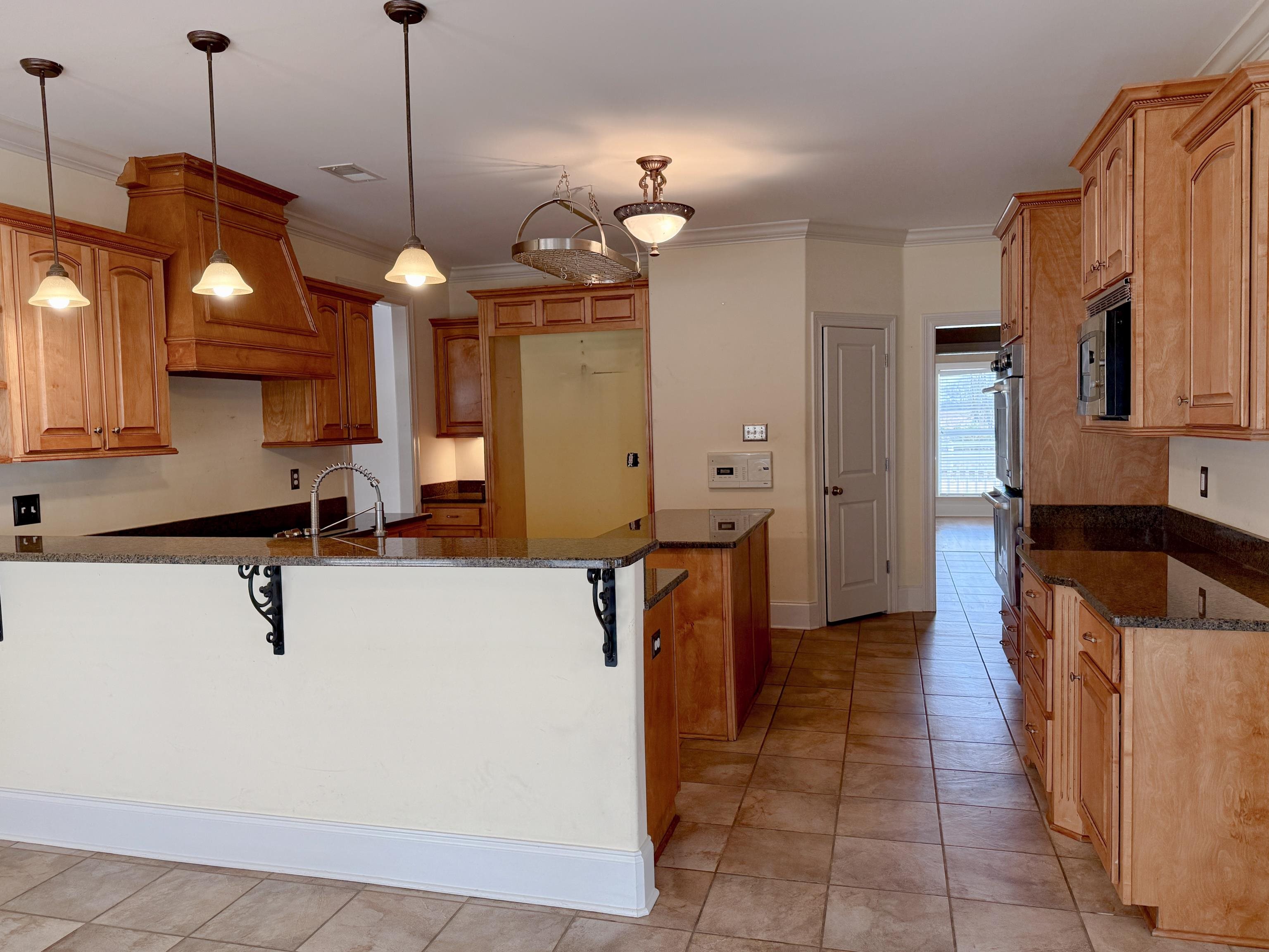 200 Diffee Road Moscow, TN 38057 - Photo 13 of 33 Kitchen featuring hanging light fixtures, a breakfast bar area, and dark stone counters