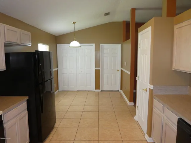 a view of a kitchen with furniture and stainless steel appliances